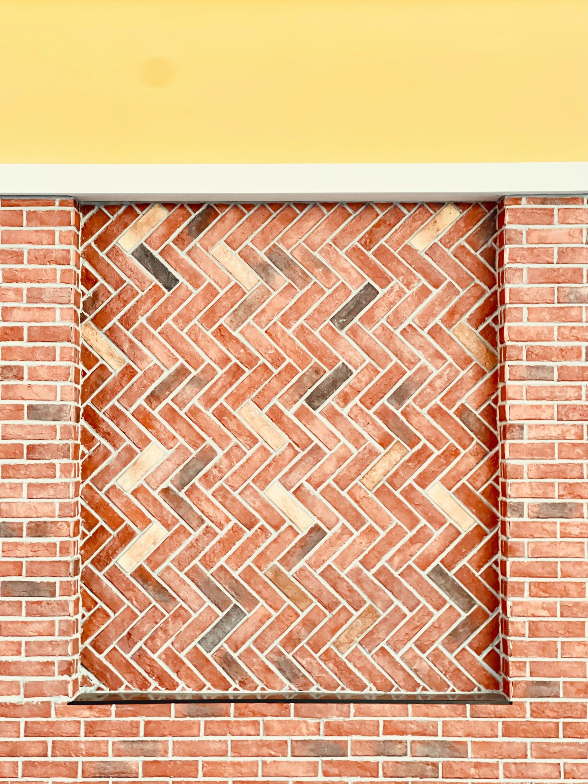 Herringbone brick pattern on a building facade.